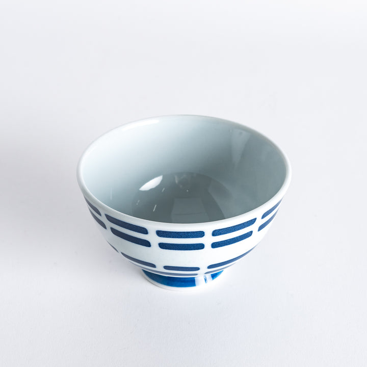 Rice bowl with navy blue line pattern, captured slightly from the side to show the design.