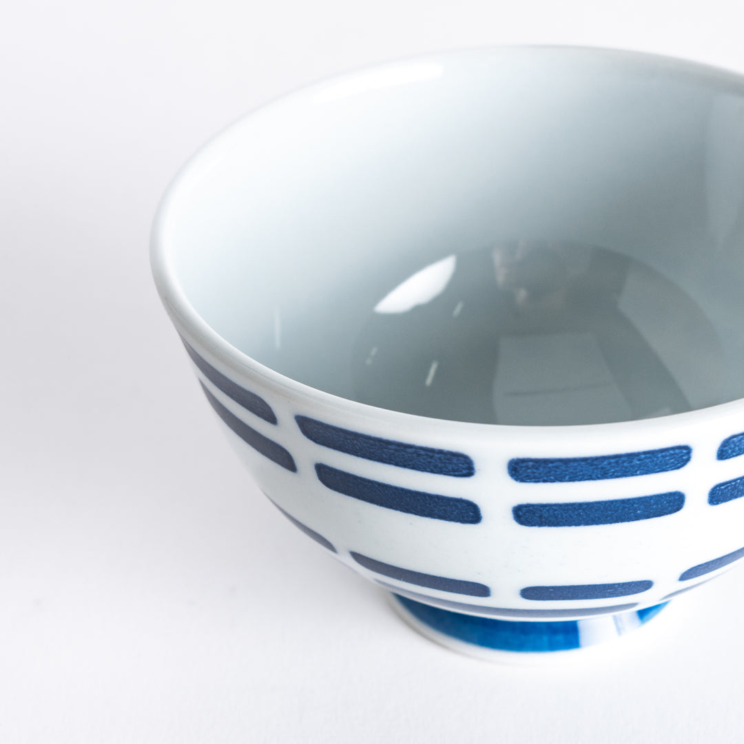 Close-up of the rice bowl with navy blue horizontal lines, taken from a slightly tilted upper angle.