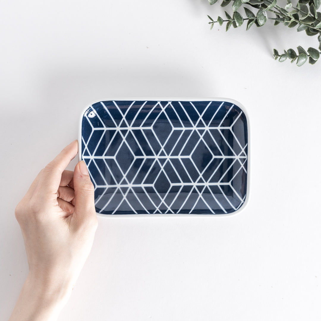 Handheld view from above, displaying the Modern Indigo Tile Dessert Plate with a geometric white and navy pattern.