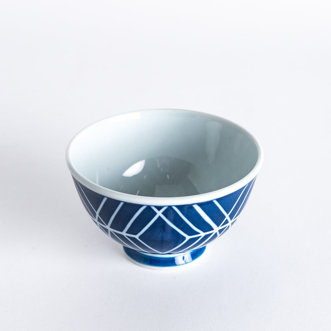 Top view of the Modern Indigo Tile Rice Bowl held in hand, showcasing the geometric navy blue pattern on a white background.