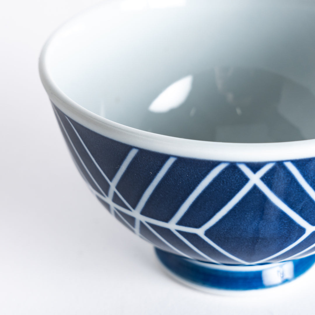 Close-up view of the Modern Indigo Tile Rice Bowl's geometric navy blue pattern, showcasing the intersecting lines and blue base.