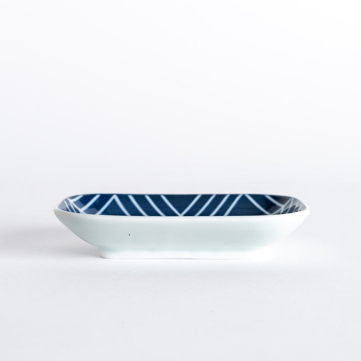 Side view of sauce dish, highlighting its rectangular shape and modern navy blue geometric pattern.