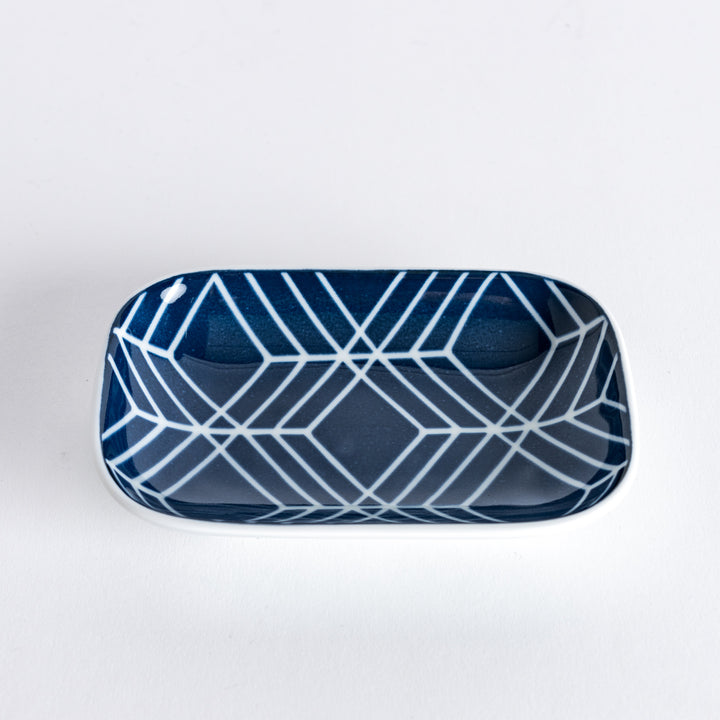 Slightly angled view of sauce dish with a geometric design, showcasing the bold navy blue lines and white background.