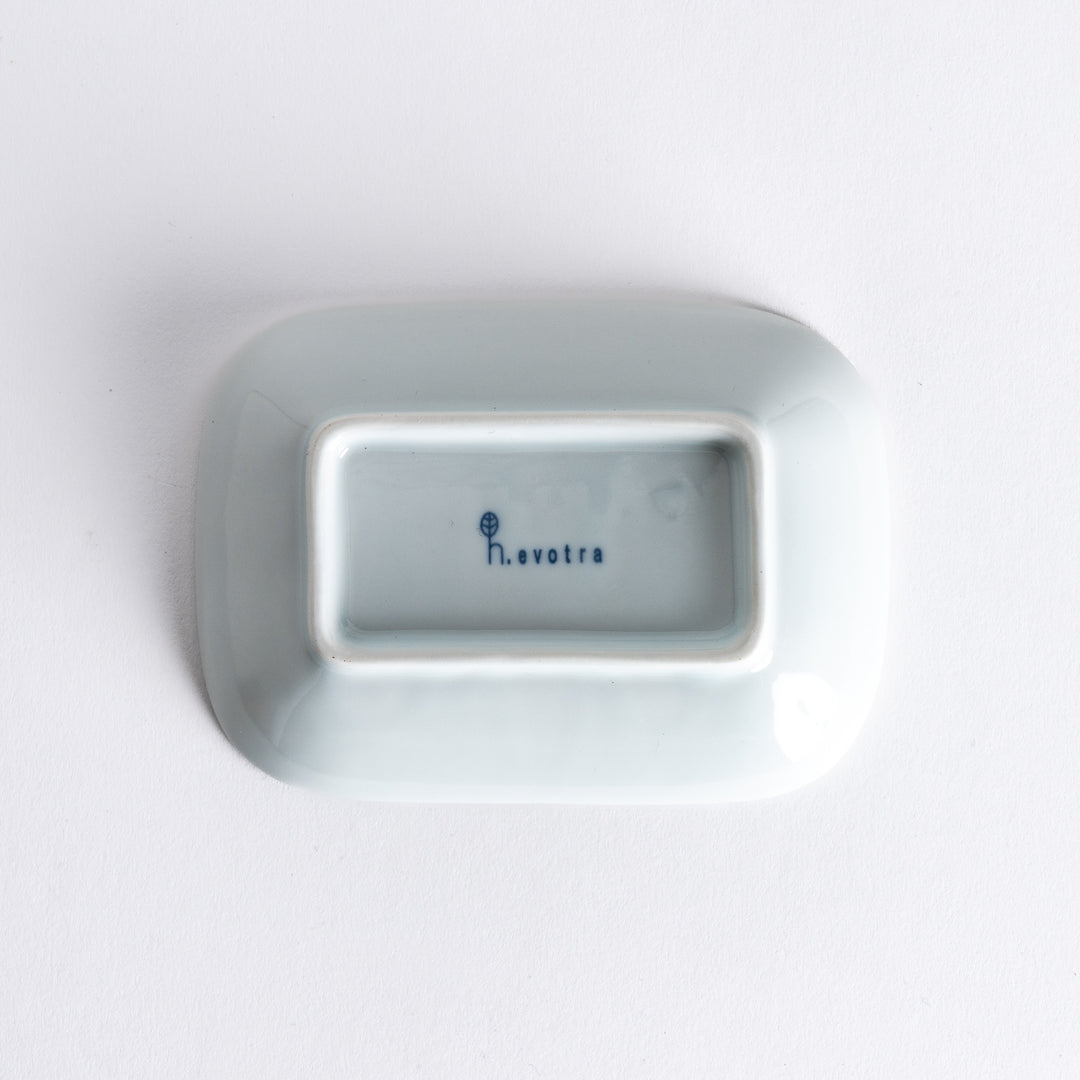 Bottom view of the sauce dish, displaying the clean white underside with the potter's name stamped.