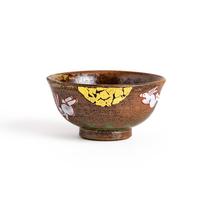 Brown ceramic sake cup with a playful rabbit design and a unique crackled glaze, perfect for enjoying a traditional cup of sake.