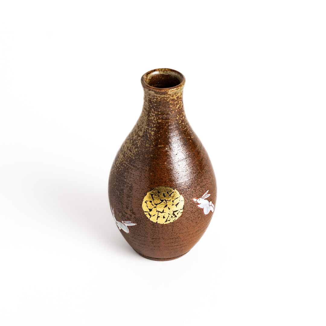 Brown ceramic sake carafe with a decorative rabbit and moon design, perfect for serving sake and adding a touch of traditional Japanese style to your table.