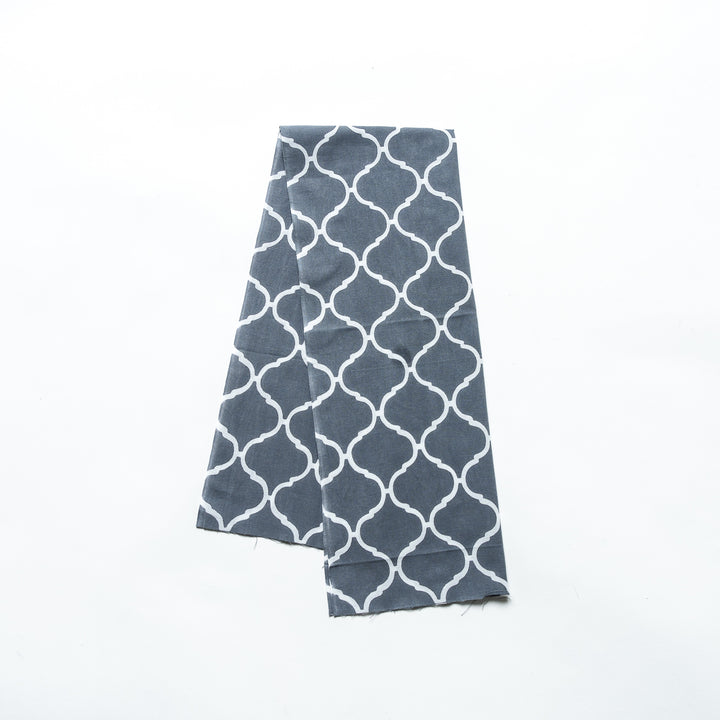 Gray hand towel featuring a Moroccan tile-inspired white lattice pattern, folded neatly.