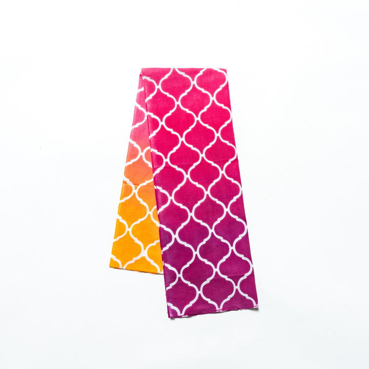 Pink hand towel featuring a Moroccan tile-inspired white lattice pattern, folded neatly.