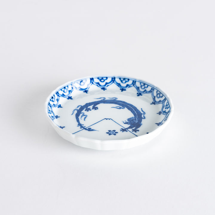 A small round ceramic plate with a blue dragon and Mount Fuji design, bordered with intricate patterns.