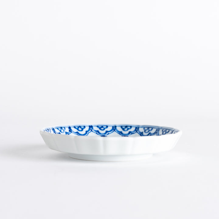 A small round ceramic plate with a blue dragon and Mount Fuji design, bordered with intricate patterns.