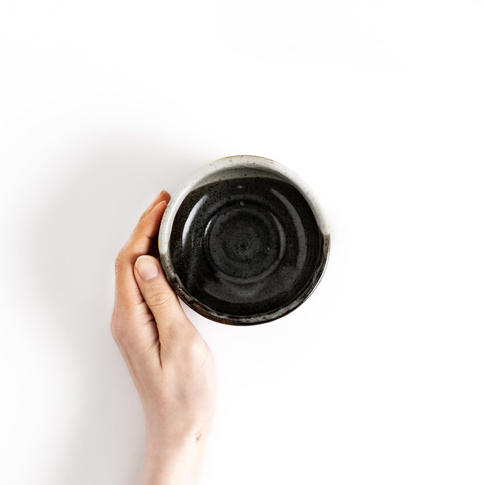 Hand holding a matcha bowl with a unique glaze, perfect for whisking and enjoying a traditional bowl of matcha.