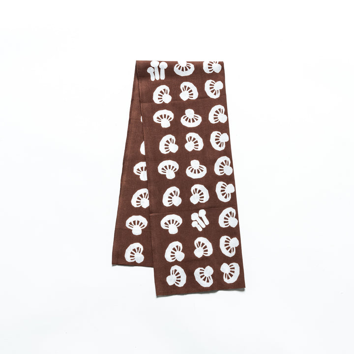 Brown tenugui with repeating white mushroom patterns, perfect for a nature-inspired touch.