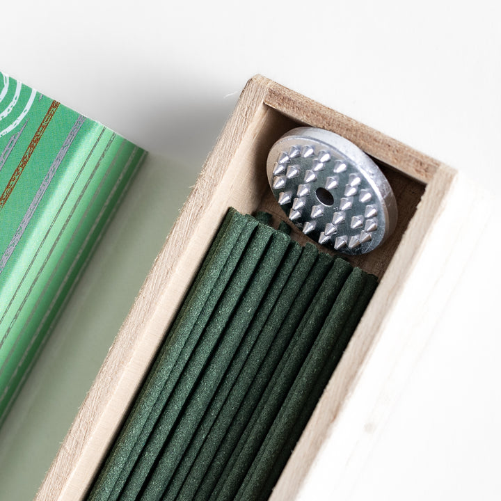 Mystic Camphor Incense in a light wooden box with deep green sticks, elegantly packaged in a soft green design featuring white circular patterns, evoking a refreshing and invigorating camphor aroma.