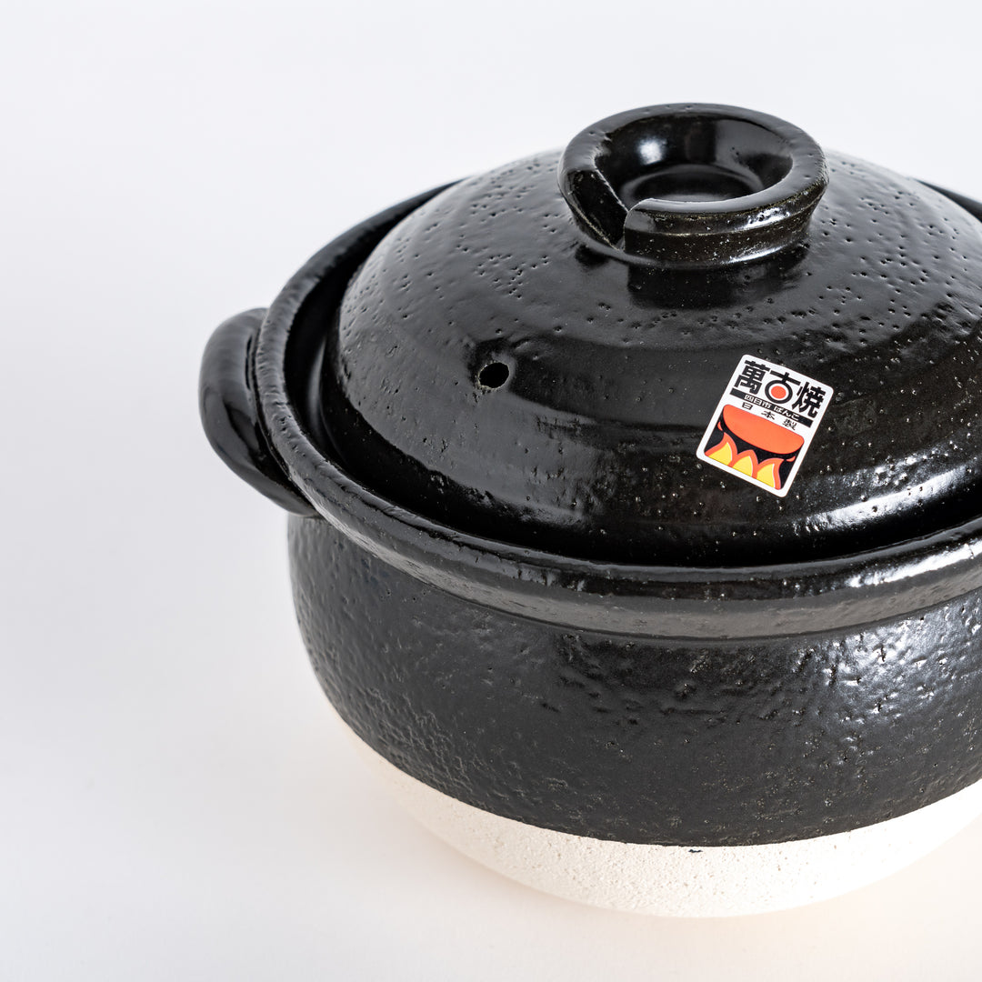 Close-up of the donabe’s glossy black lid, capturing its smooth texture and centered handle.