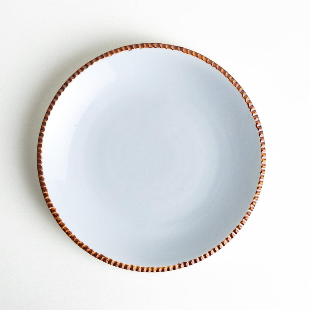 A round white dinner plate with a rustic scallop-edged border. The border comes in blue, brown, and olive.