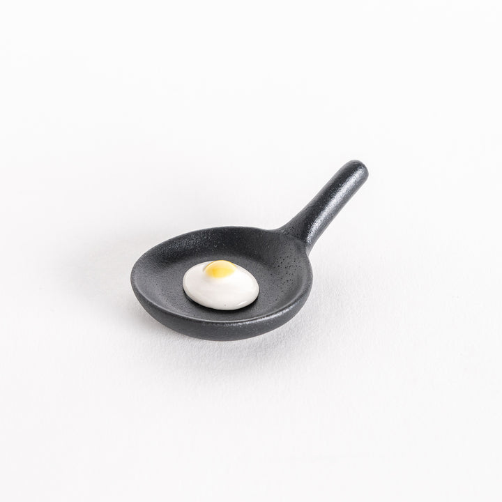 Slightly angled view of the frying pan chopsticks rest, showcasing the handle and egg details.