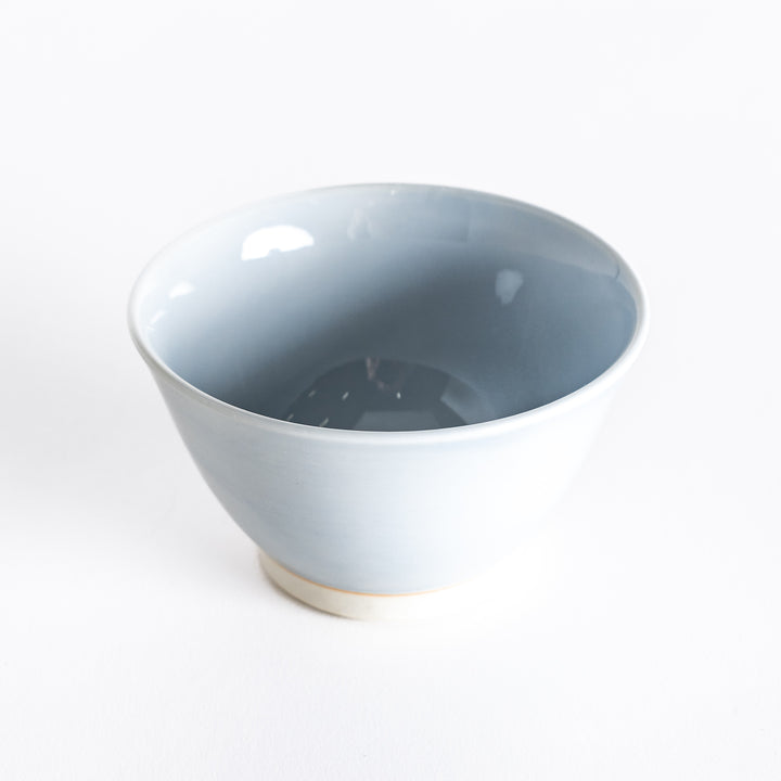 A light blue dessert bowl, photographed at a slight angle, highlighting its elegant curves and serene color.