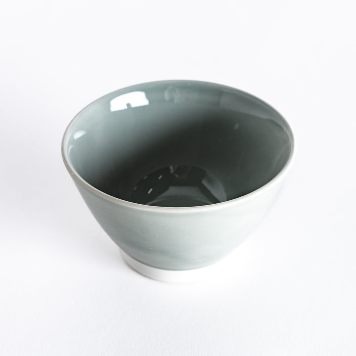 A pastel gray dessert bowl, photographed at a slight angle, highlighting its modern design and soft gray color.