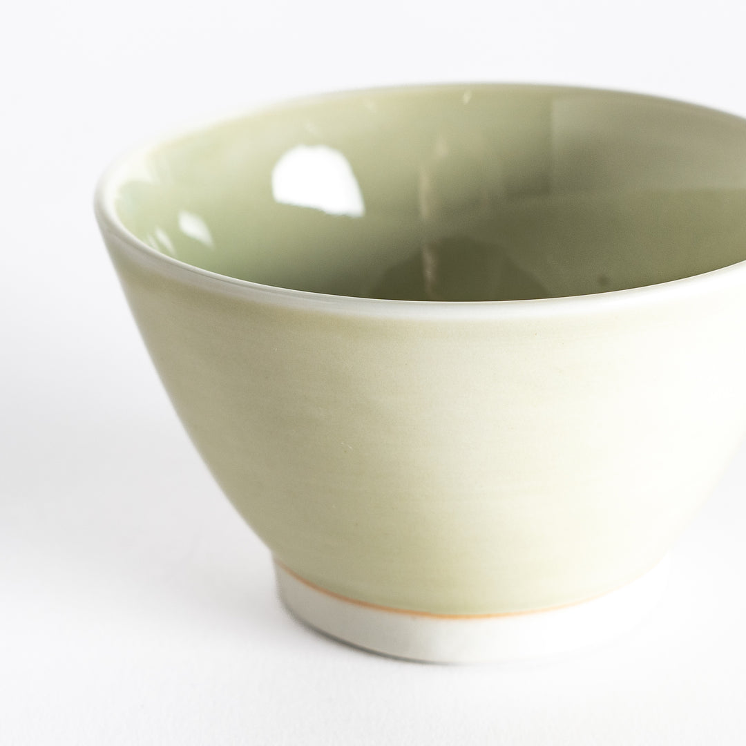 Close-up of a light green dessert bowl, focusing on its delicate ceramic texture and soft pastel hue.