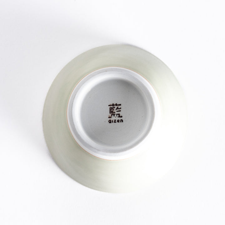 Bottom view of a light green dessert bowl, featuring a white base and clean, simple design.