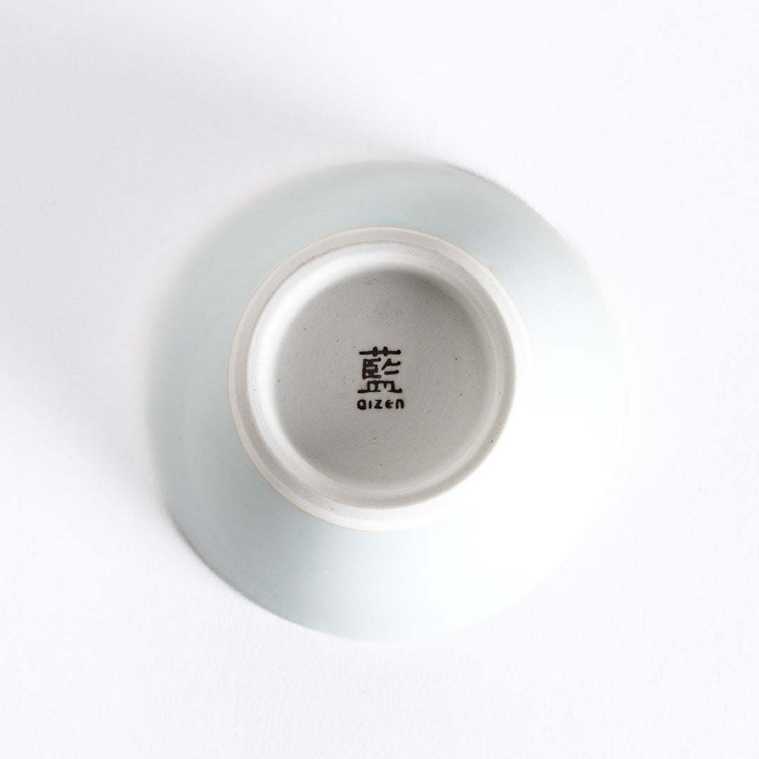 Bottom view of a blue-tinted white dessert bowl, featuring its sturdy white base and minimalist style.