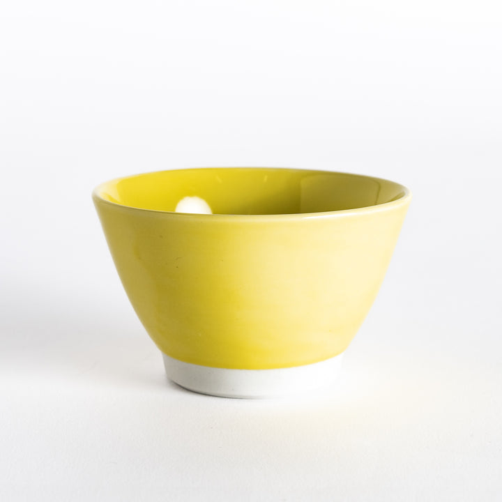 Bright yellow dessert bowl, viewed from the front, with a glossy finish and elegant curved form.