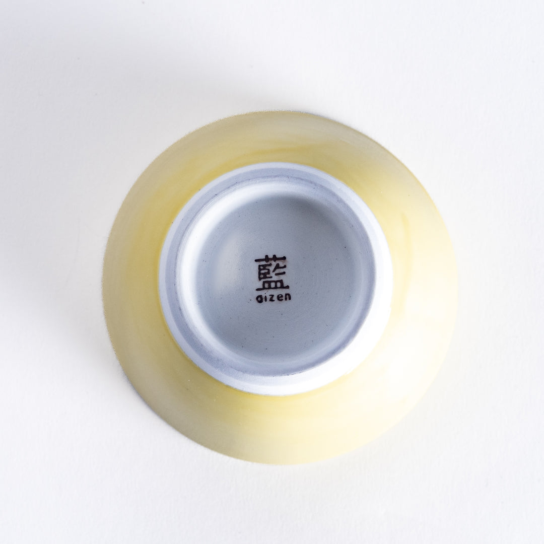 Bottom view of a bright yellow dessert bowl, featuring a white base and clean, simple construction.