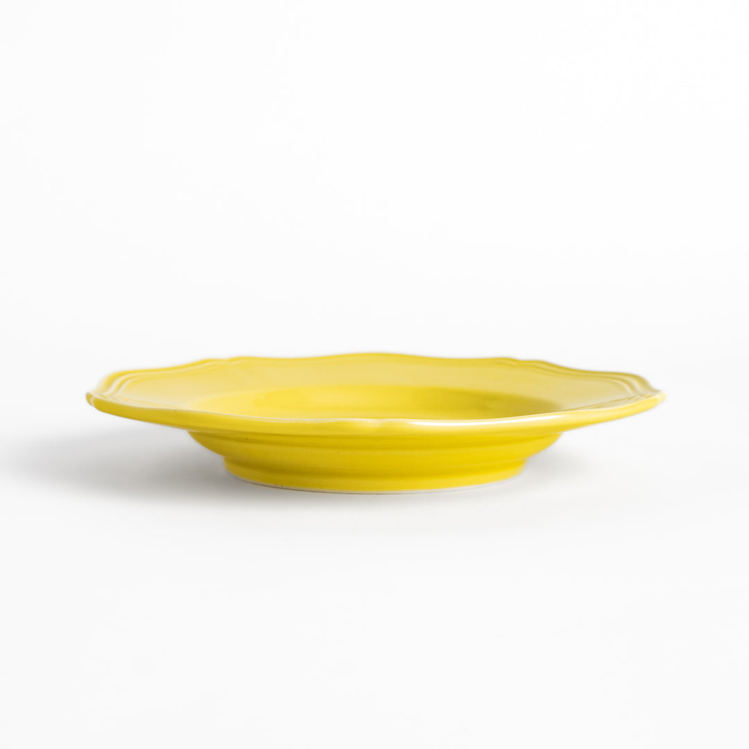 Pretty yellow dessert plate with a delicate scalloped edge, ideal for showcasing your favorite treats.