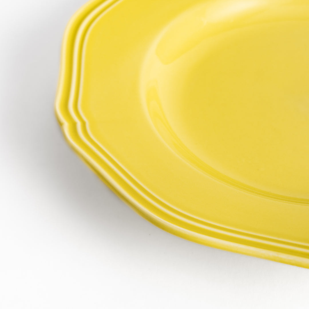 Pretty yellow dessert plate with a delicate scalloped edge, ideal for showcasing your favorite treats.