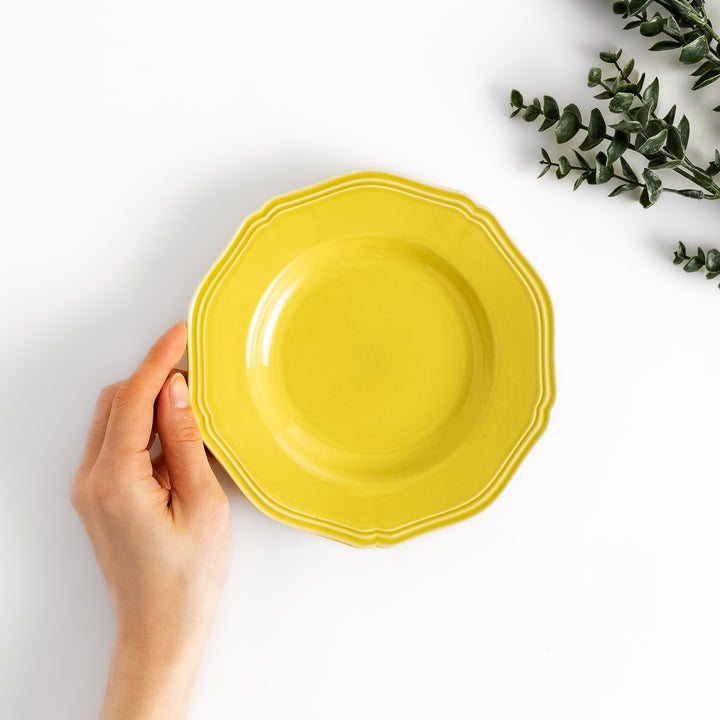 Pretty yellow dessert plate with a delicate scalloped edge, ideal for showcasing your favorite treats.