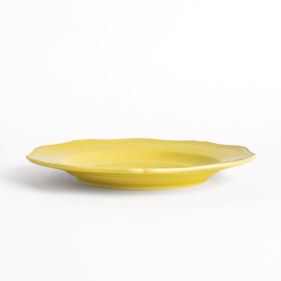 Pretty yellow dinner plate with a delicate scalloped edge, ideal for showcasing your culinary creations.