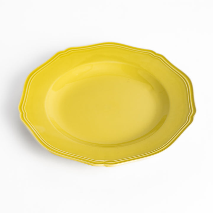 Pretty yellow dinner plate with a delicate scalloped edge, ideal for showcasing your culinary creations.