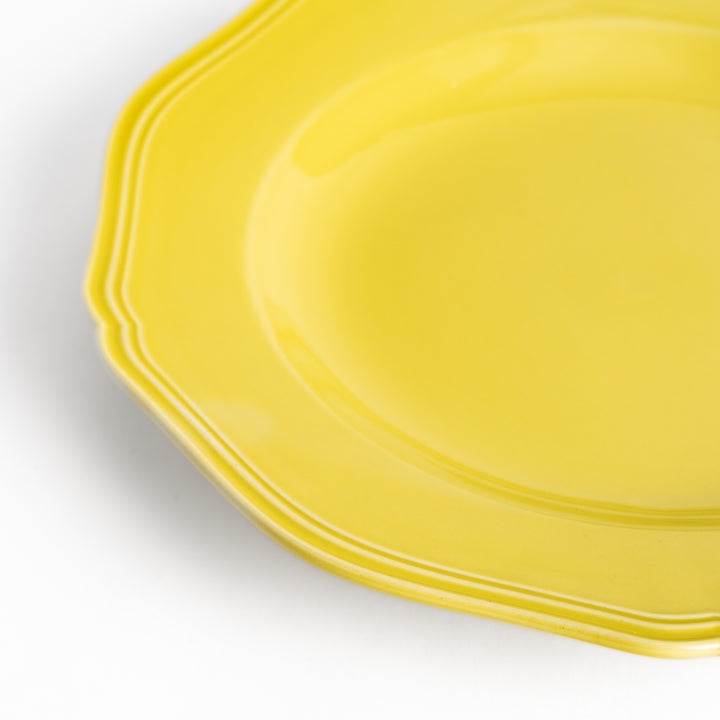 Pretty yellow dinner plate with a delicate scalloped edge, ideal for showcasing your culinary creations.