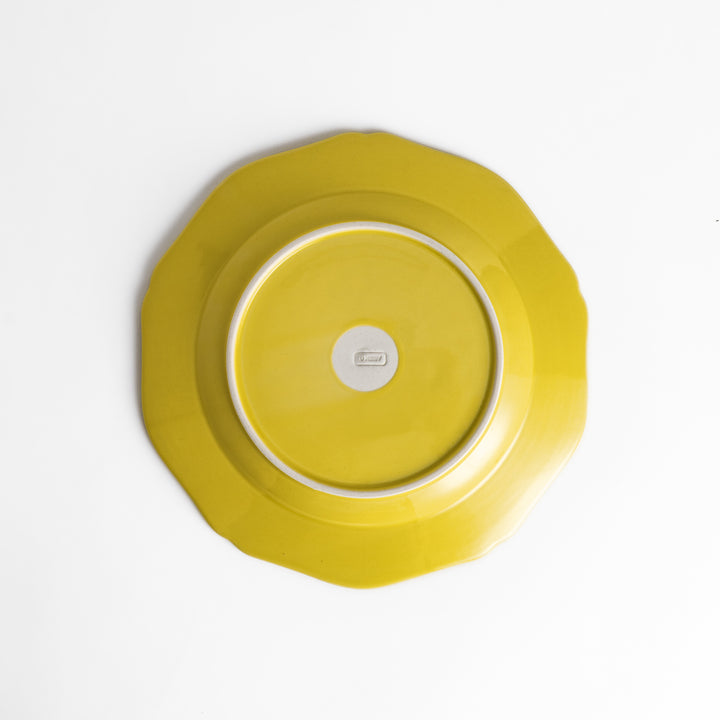 Pretty yellow dinner plate with a delicate scalloped edge, ideal for showcasing your culinary creations.