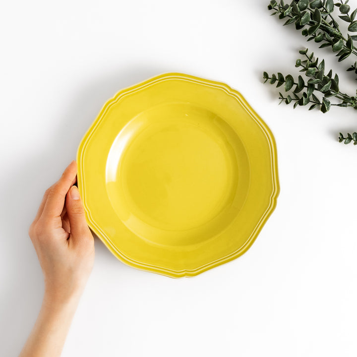 Pretty yellow dinner plate with a delicate scalloped edge, ideal for showcasing your culinary creations.