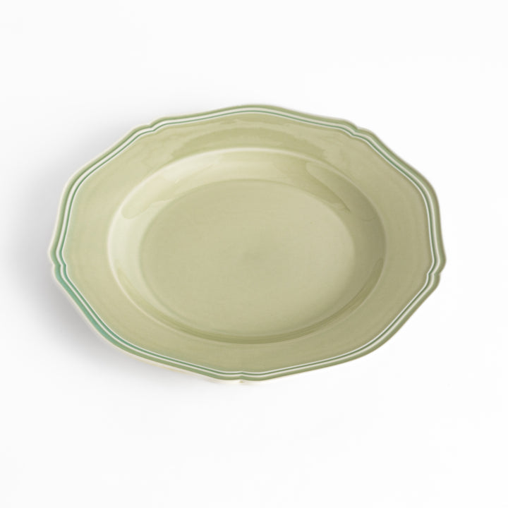 Pretty green dinner plate with a delicate scalloped edge, ideal for showcasing your culinary creations.