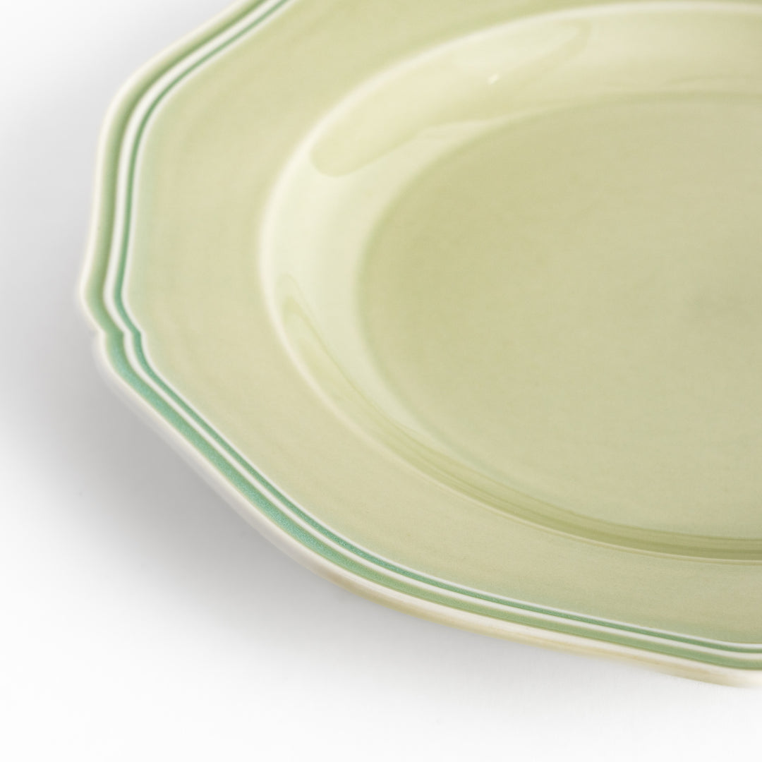 Pretty green dinner plate with a delicate scalloped edge, ideal for showcasing your culinary creations.