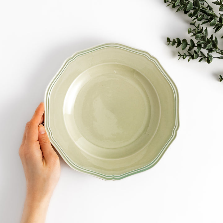 Pretty green dinner plate with a delicate scalloped edge, ideal for showcasing your culinary creations.