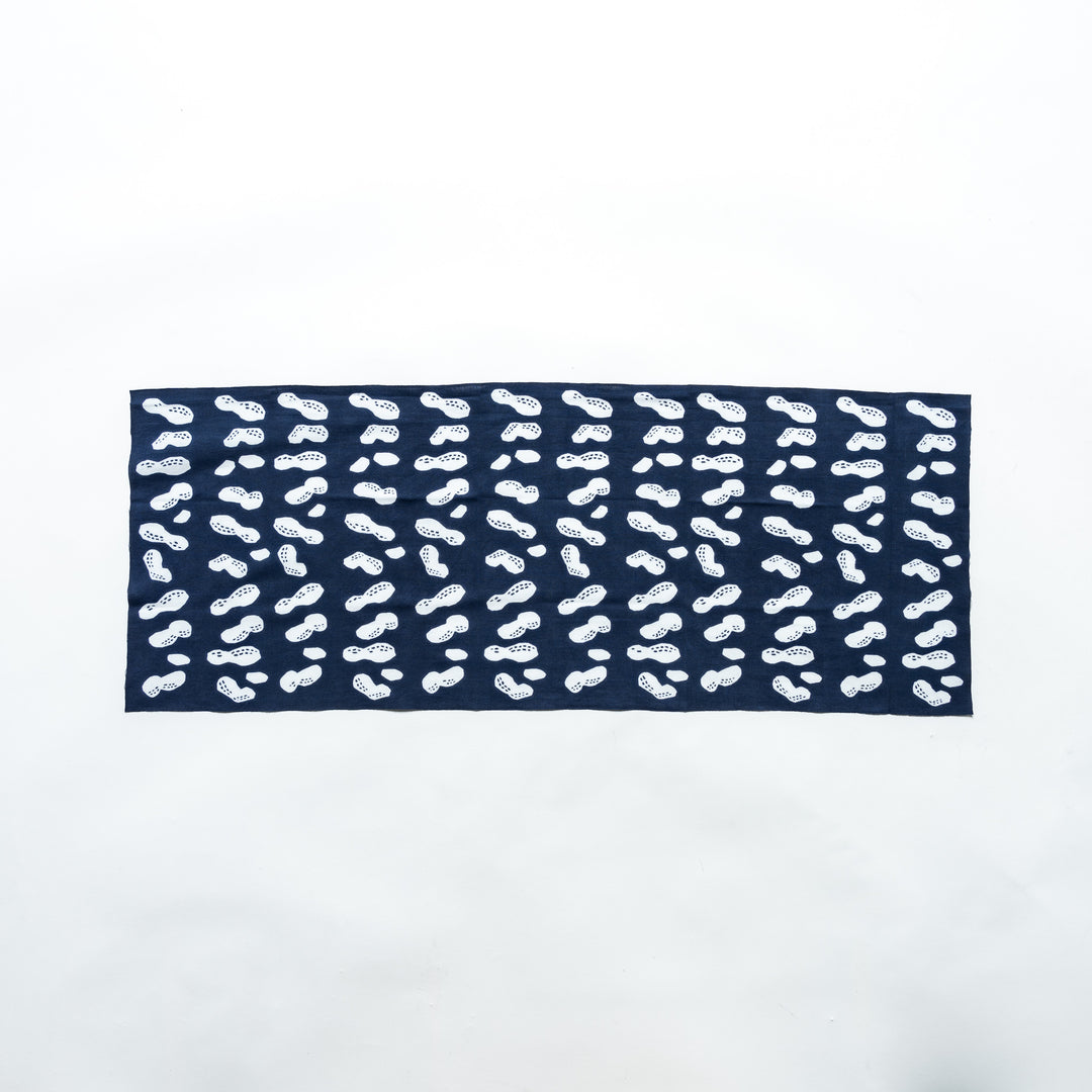 Navy hand towel featuring white peanut motifs, fully spread to display its design.