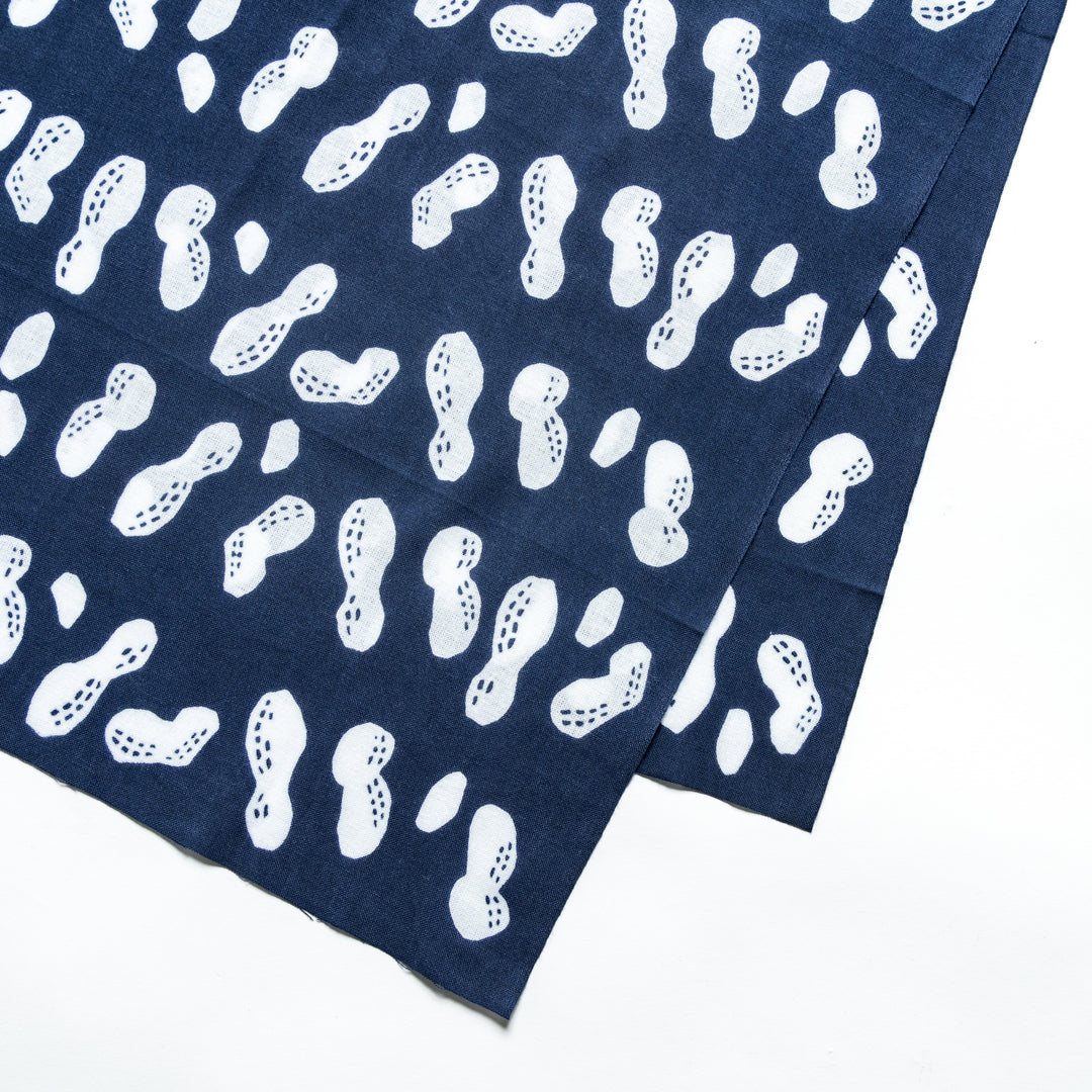 Close-up of white peanut patterns on navy hand towel fabric.