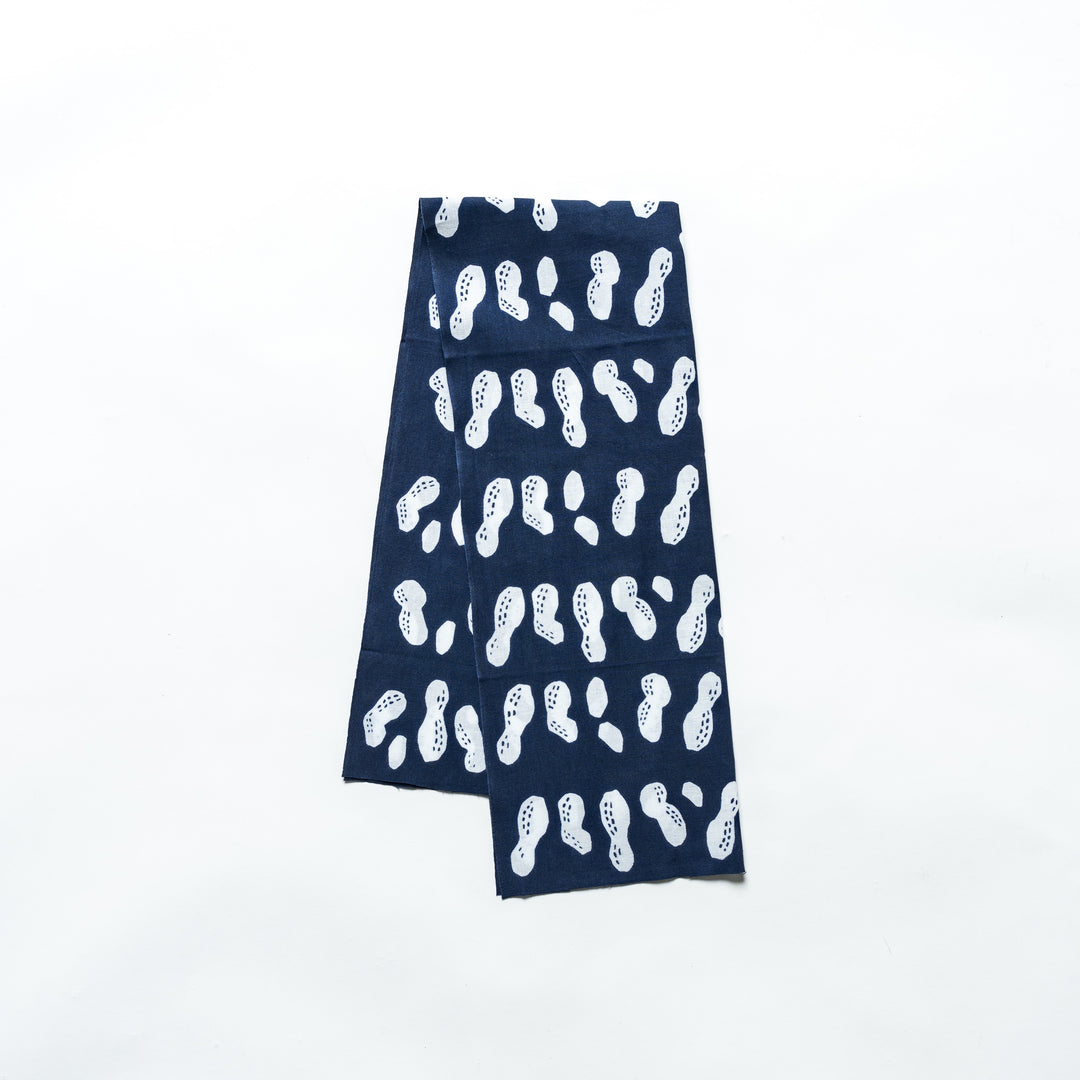 Navy hand towel with white peanut patterns neatly folded.