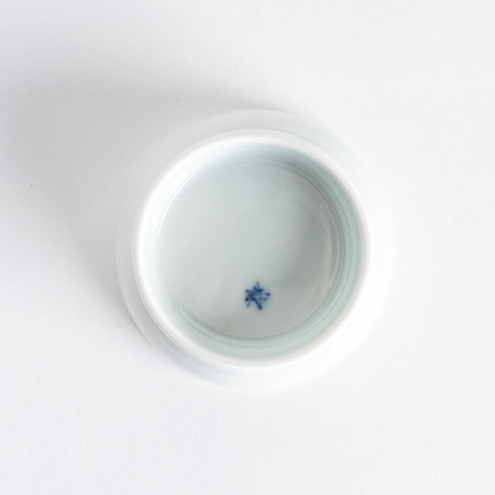 A small porcelain dish with a simple, elegant blue illustration of two persimmons.