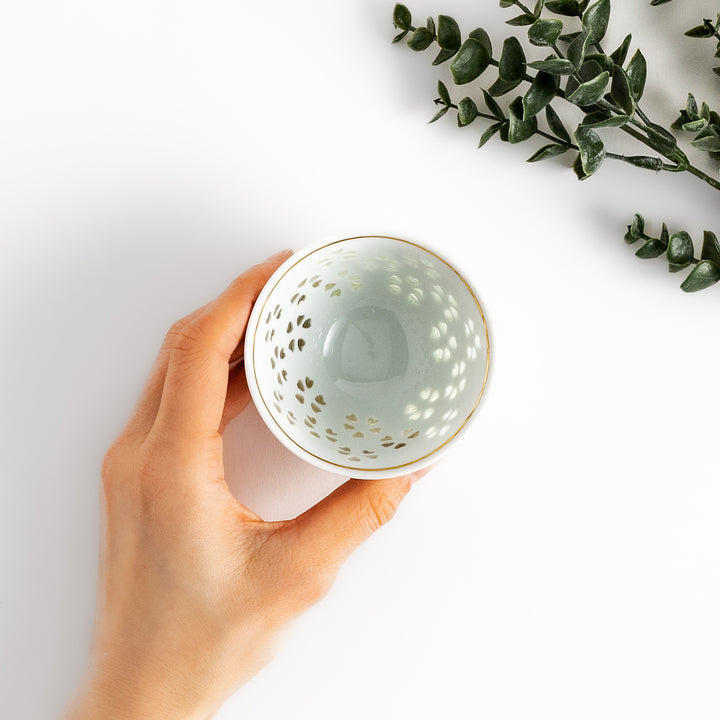 Delicate white teacup with a unique cut-out heart design, perfect for adding a touch of romance to your tea time.