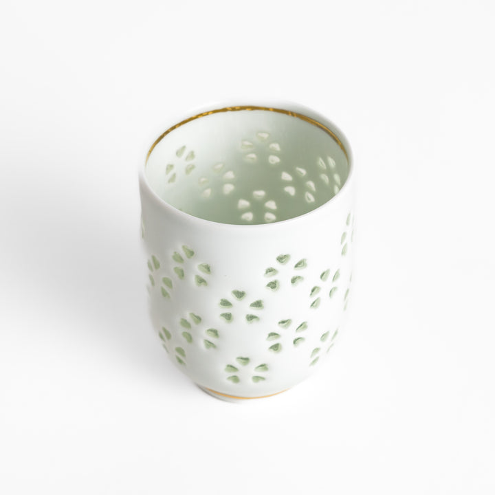 Elegant ceramic teacup featuring a subtle textured pattern and delicate gold trim, ideal for savoring your favorite brew.