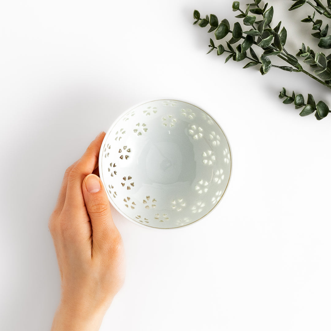 Elegant ceramic rice bowl with a delicate cut-out floral design, perfect for adding a touch of elegance to any meal.