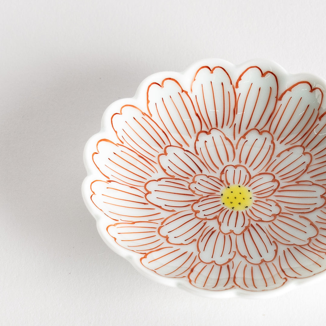 A small round dessert bowl with a delicate blue chrysanthemum pattern and scalloped edges.