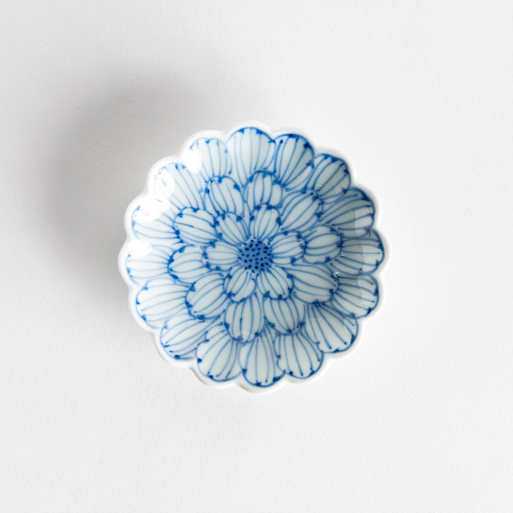 A small round dessert bowl with a delicate blue chrysanthemum pattern and scalloped edges.