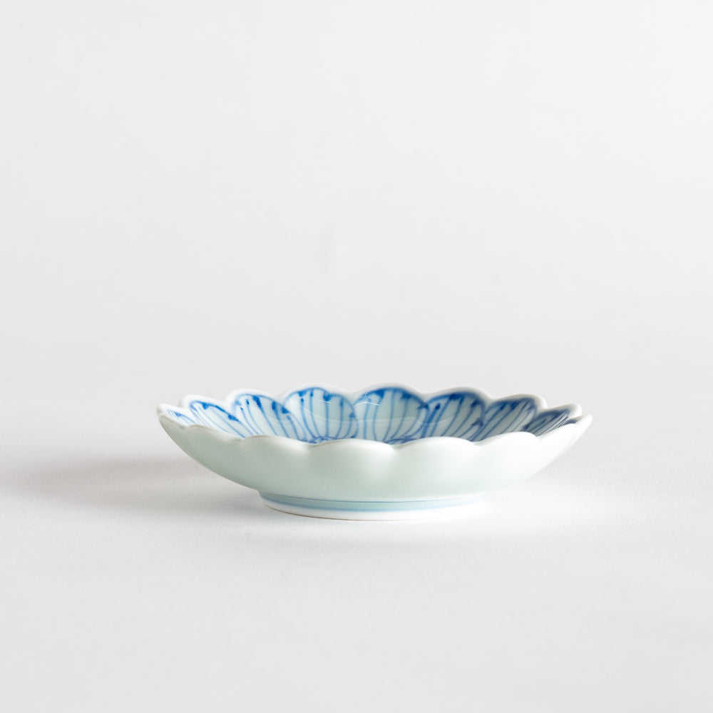 A small round dessert bowl with a delicate blue chrysanthemum pattern and scalloped edges.