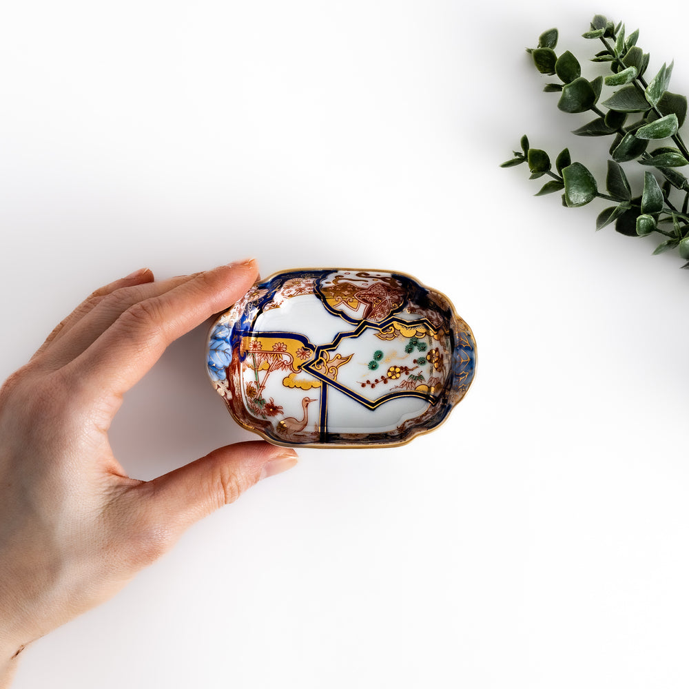 Hand-held Condiment Bowl showcasing intricate pine, bamboo, and plum patterns with cranes, framed by gold accents and flared edges.