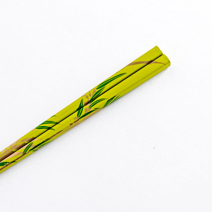 Close-up of the handle of green chopstick with bamboo pattern, displaying the intricate design clearly.